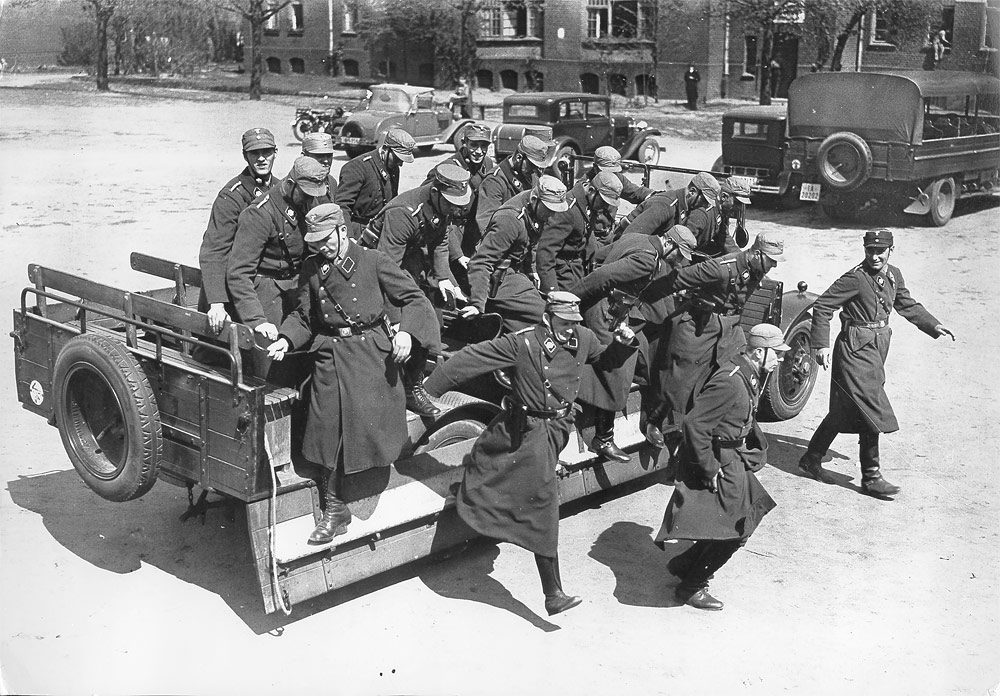 SA-Feldpolizisten beim Absteigen von einem offenen Wagen vor dem Gebäude, in dem sich heute der Gedenkort befindet, März 1933. Fotoarchiv Hoffmann / Bayerische Staatsbibliothek